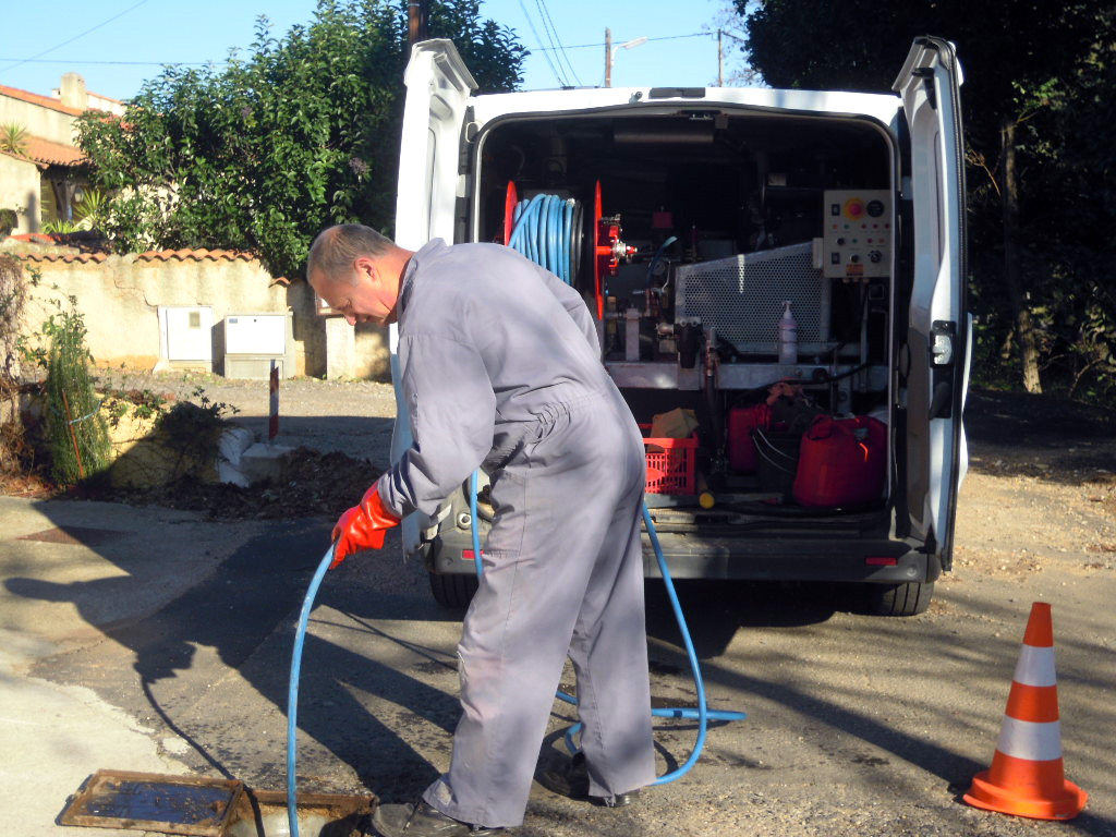 Débouchage de canalisation avec l'équipement professionnel et le camion d'urgence égouts